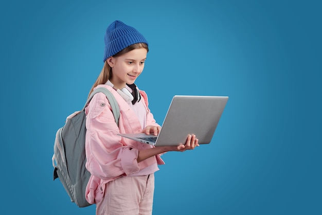 Conteúdo adolescente moderna com mochila navegando na internet no laptop