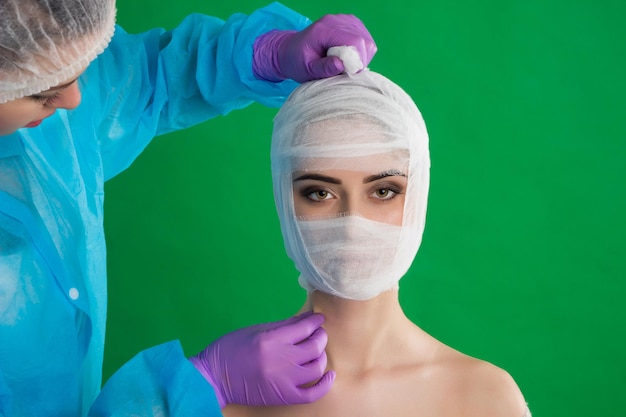 Foto en el contexto de cromakey, el médico con guantes está atando a la mujer con una venda