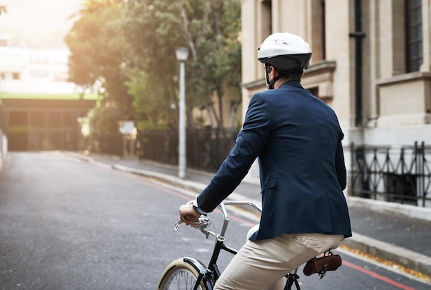 Continue avançando Foto retrospectiva de um jovem empresário bonito andando de bicicleta para trabalhar de manhã