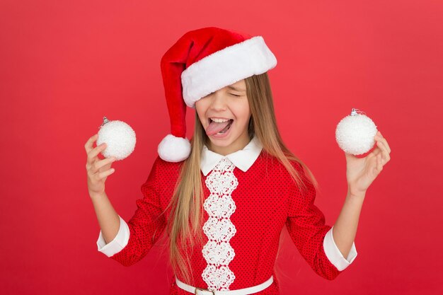 Continue comemorando, porque o ano novo está chegando. Garota feliz comemorando o Natal e o ano novo. Criança pequena gosta de comemorar as férias de inverno. Tempo de celebração. Comemorando no estilo do Papai Noel.