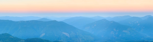 Contorno de montanha no fundo do céu da manhã. Vista superior enevoada do amanhecer de verão (Gorgany, Cárpatos, Ucrânia). Onze fotos costuram um panorama de alta resolução.