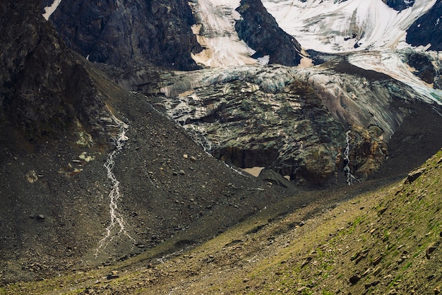 Contrafortes de geleiras gigantes. Incrível relevo rochoso com neve e gelo. Parede natural rochosa maravilhosa montanha enorme com pequenas cachoeiras. Água da geleira. Arte fantástica da natureza majestosa das montanhas.