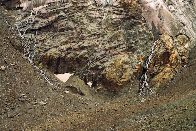 Contrafortes de geleiras gigantes. Incrível relevo rochoso com neve e gelo. Parede natural rochosa maravilhosa montanha enorme com pequenas cachoeiras. Água da geleira. Arte fantástica da natureza majestosa das montanhas.