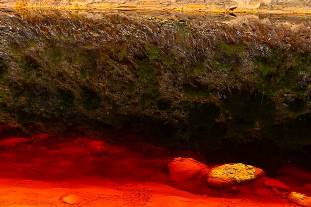 Contraste de sedimentos vermelhos e águas refletoras em rio tinto