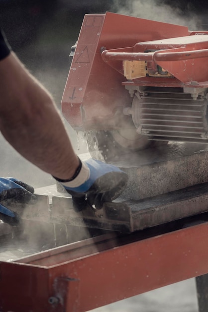 Contratista cortando un bloque de hormigón en una nube de polvo con una amoladora angular