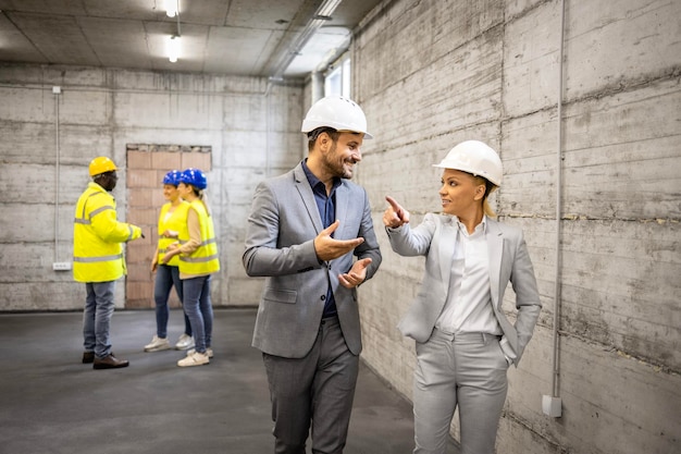 Foto contratista y diseñador de interiores visitando el sitio de construcción y visualizando el diseño del proyecto