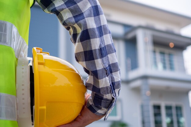 El contratista masculino está mirando el área del proyecto de la casa que se le ha asignado hacer. Verifique la preparación de la casa antes de enviársela al propietario.