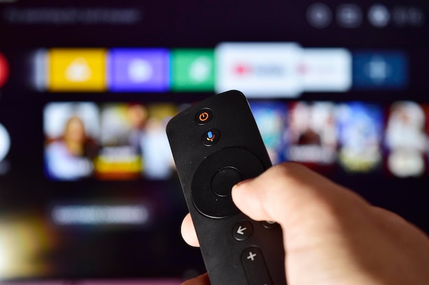 Control remoto de Smart TV en la mano cambiando el canal de TV