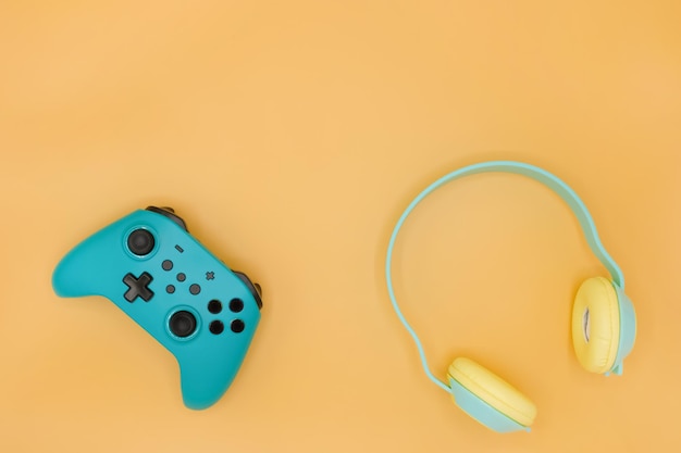 Controlador de jogos de joystick verde com fones de ouvido sem fio verdes isolados em fundo amarelo pastel