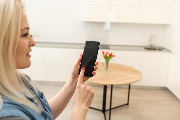 Controlando a temperatura e a intensidade da lâmpada com um aplicativo para smartphone. Conceito de uma casa inteligente e gerenciamento de luz com dispositivos móveis.