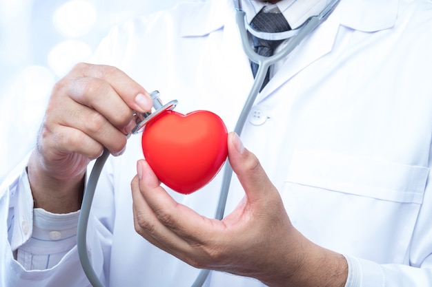 controle para arriba en una bola roja del corazón en oficina de la falta de definición en el fondo del hospital y del bokeh.