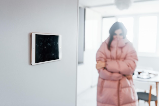 Controle climático A jovem está dentro de casa na sala da casa inteligente durante o dia