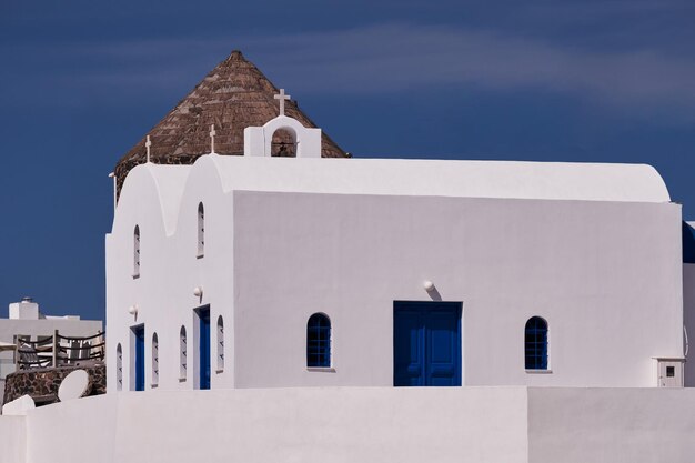 Foto convento de são nicolau e um moinho de vento tradicional na aldeia de imerovigli, santorini, grécia