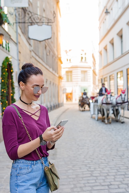 Conversa da mulher por seu smartphone na cidade. jovem atrativos turísticos ao ar livre na cidade italiana