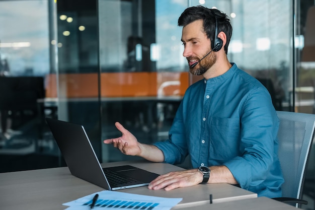 Conversa de negócios. Gerente masculino em fones de ouvido tendo uma chamada de vídeo