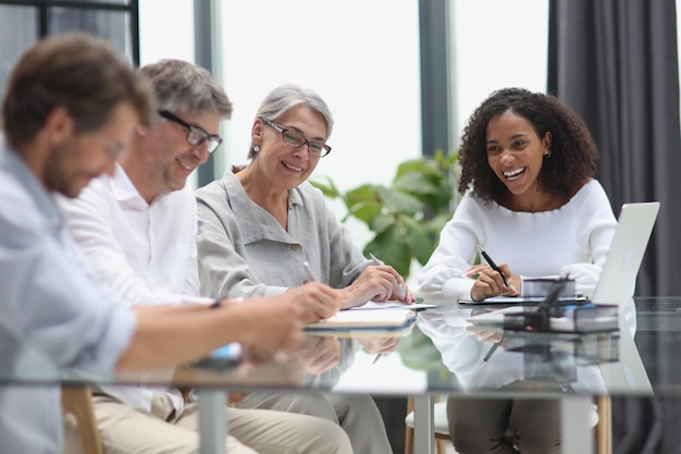 Conversa entre gerentes e empregados no escritório à mesa