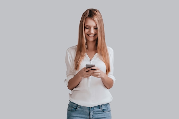conversando com o namorado. jovem atraente no casual wear segurando um telefone inteligente