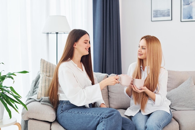 Conversando Jovem mãe com sua filha está em casa durante o dia