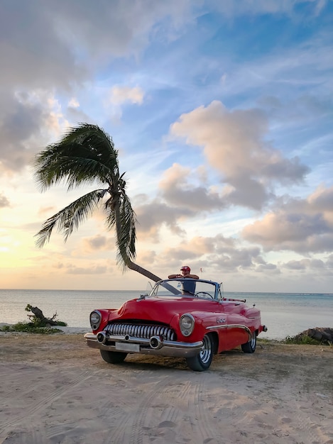 Conversível vermelho em uma praia tropical