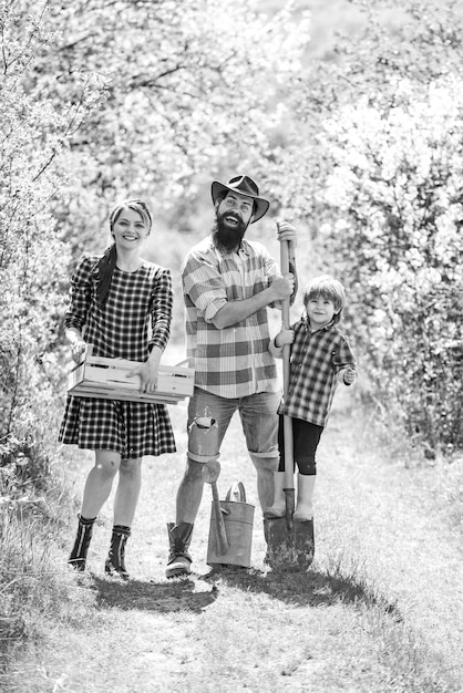 Conviértanse en agricultores orgánicos Retrato de esposa y esposo con hijo mientras trabajan en el jardín Trabajo familiar