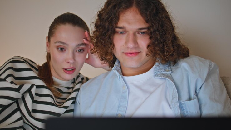 Foto los cónyuges viendo contenido de redes sociales en la computadora portátil sentados por la noche en el apartamento de cerca
