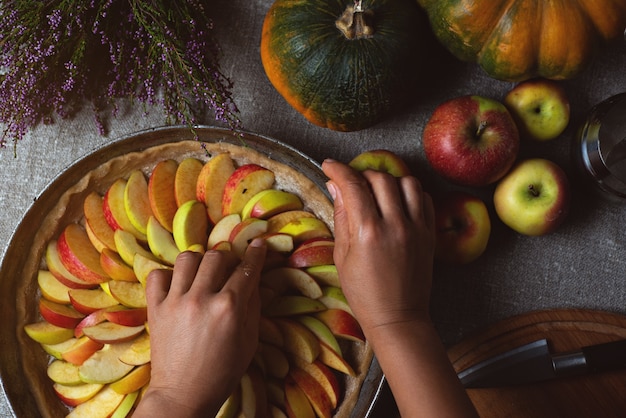 Cook coloca un trozo de manzana sobre la superficie de la masa