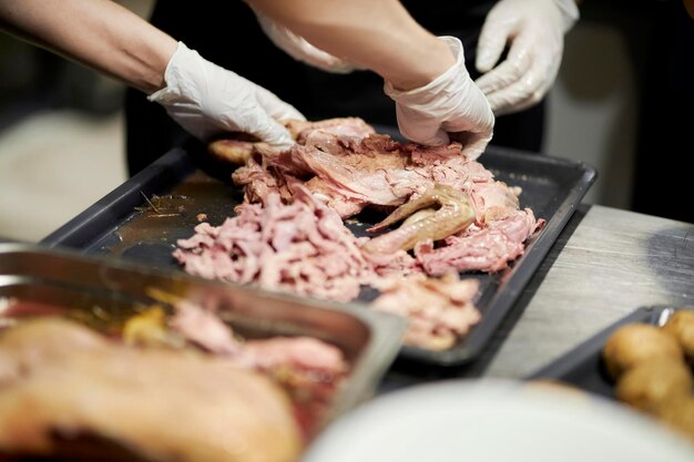 Foto cook crush gekochtes hähnchen, nahaufnahme in zeitlupe. nahaufnahmehände schneiden gekochte hähnchenschenkel.