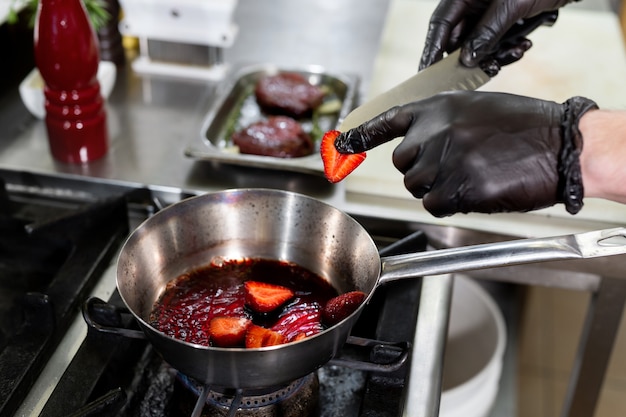 Cook está friendo fresas en una sartén