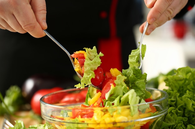 Cook hält die Gabel in der Hand und mischt