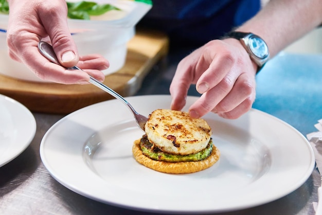 Cook se sirve plato con chuleta de pescado en el restaurante