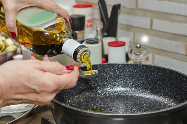 Cook vierte aceite en una sartén para saltear verduras en la estufa de gas