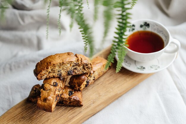 Cookies biscotti italianos com uma xícara de chá preto sobre uma toalha de mesa leve. vista superior da foto aconchegante