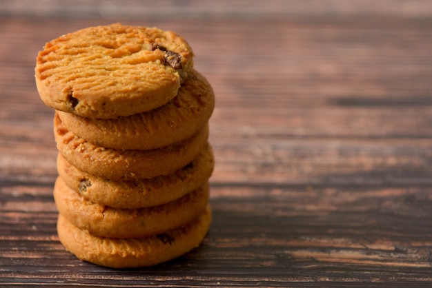 Cookies da aveia e dos pedaços de chocolate no fundo de madeira rústico da tabela, espaço da cópia.