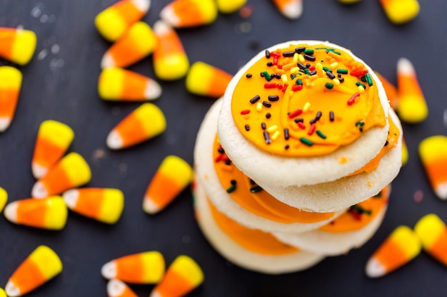 Cookies de açúcar de Halloween com cobertura de laranjas e granulado por cima.