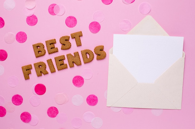 Cookies de cartas melhores amigos com cartão e confetes em rosa