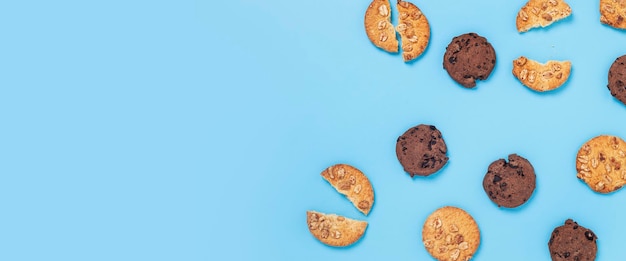 Cookies de chocolate com chocolate, cookies com nozes sobre um fundo azul. Vista superior, configuração plana. Bandeira.