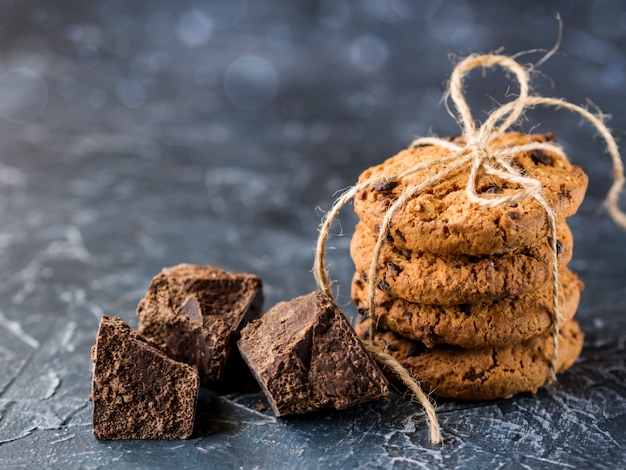 Cookies de chocolate, empilhados e amarrados com uma corda, pedaços de chocolate preto