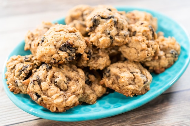 Cookies de passas de aveia em borracha recém-assados em um prato azul.