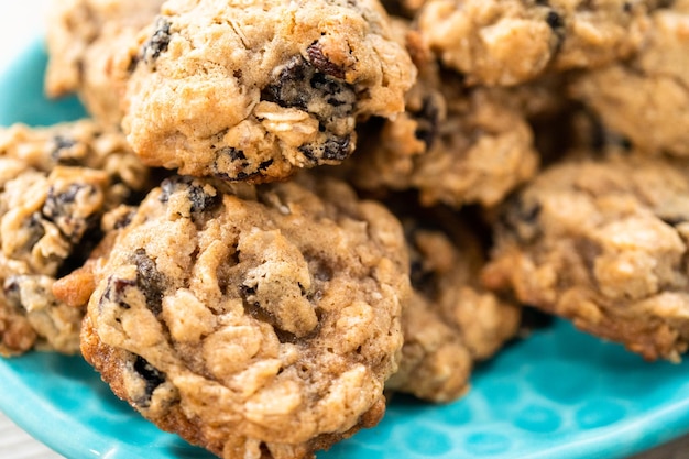 Cookies de passas de aveia em borracha recém-assados em um prato azul.