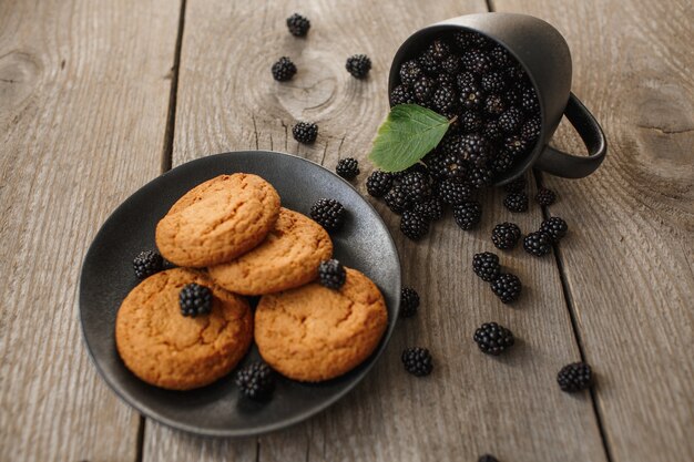 Cookies e amoras em um fundo de madeira