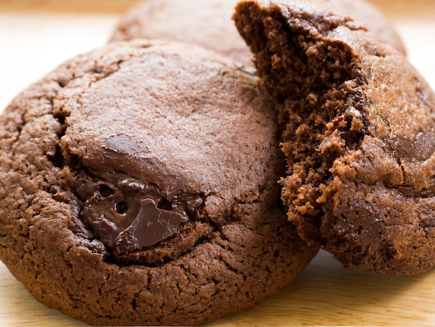 Cookies escuras macias caseiros da brownie do chocolate colocadas em uma placa de madeira.