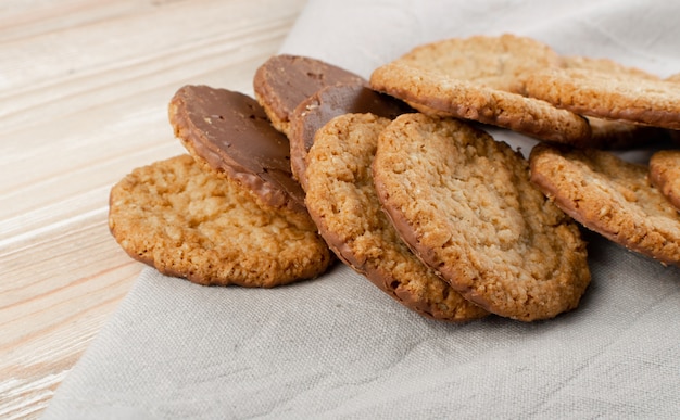 Cookies finos de aveia ou biscoitos de aveia de cereais saudáveis com chocolate. biscoito crocante de anzac com flocos de aveia no fundo da mesa rústica