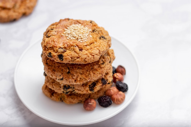 Cookies friáveis de aveia fresca em um prato com nozes e passas