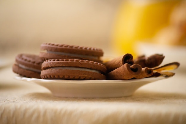 Cookies redondos de chocolate com uma camada e recheio em um prato decorado com canela