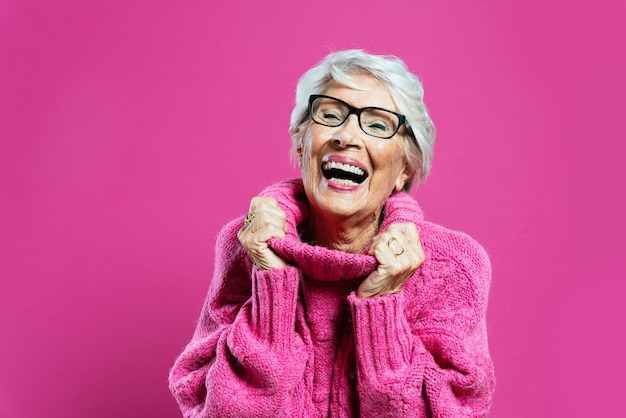 Cool abuela posando en estudio vistiendo ropa de moda y haciendo fiesta