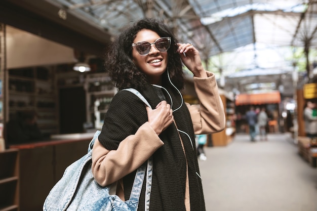 Cool chica afroamericana con gafas de sol y auriculares