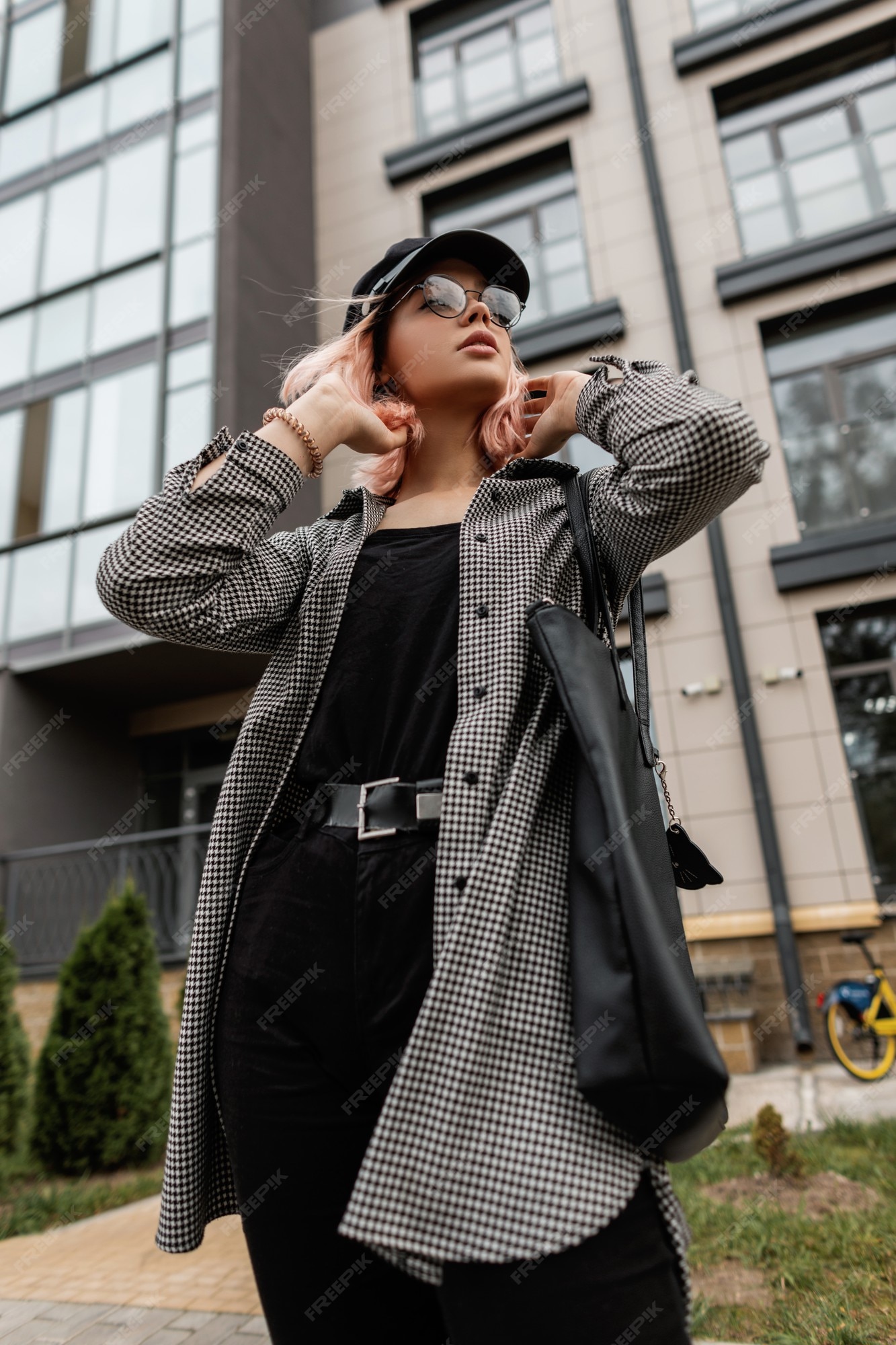 Cool elegante hermosa mujer con gafas y una en ropa de jeans de moda casual con una bolsa camina en la cerca del edificio | Foto Premium