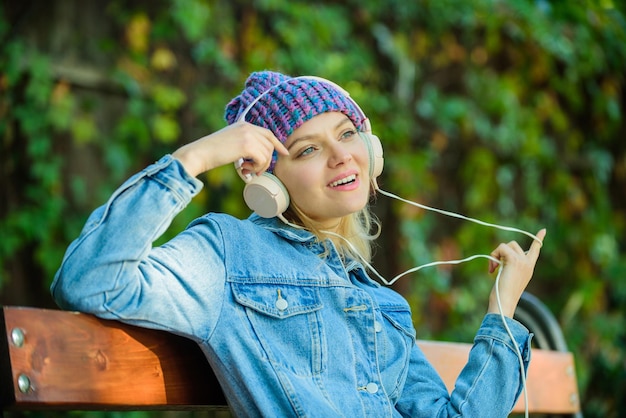 Cool funky girl disfruta de la música en auriculares al aire libre Chica escucha música en el parque Sonido de melodía y mp3 Concepto de fanático de la música Los auriculares deben tener un dispositivo moderno Disfruta de un sonido potente Sentirse increíble