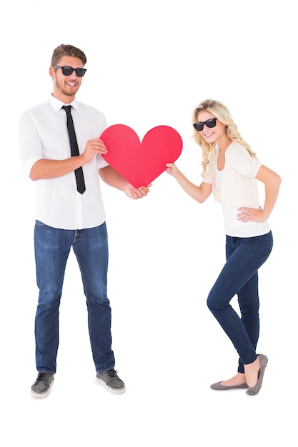 Cool jovem casal segurando coração vermelho