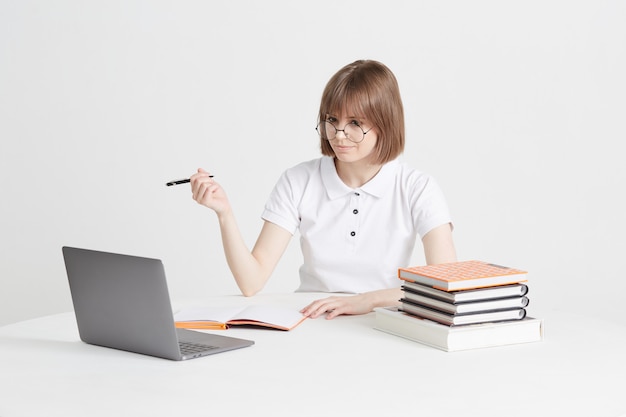 Cool mujer feliz pasa por la formación en línea sentado en su casa. Educación escolar remota en una computadora portátil. Quédate en casa lecciones.